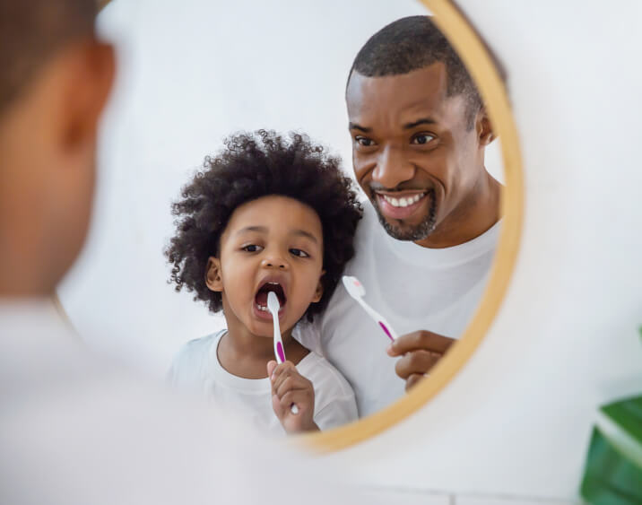 son and father brushing teeth